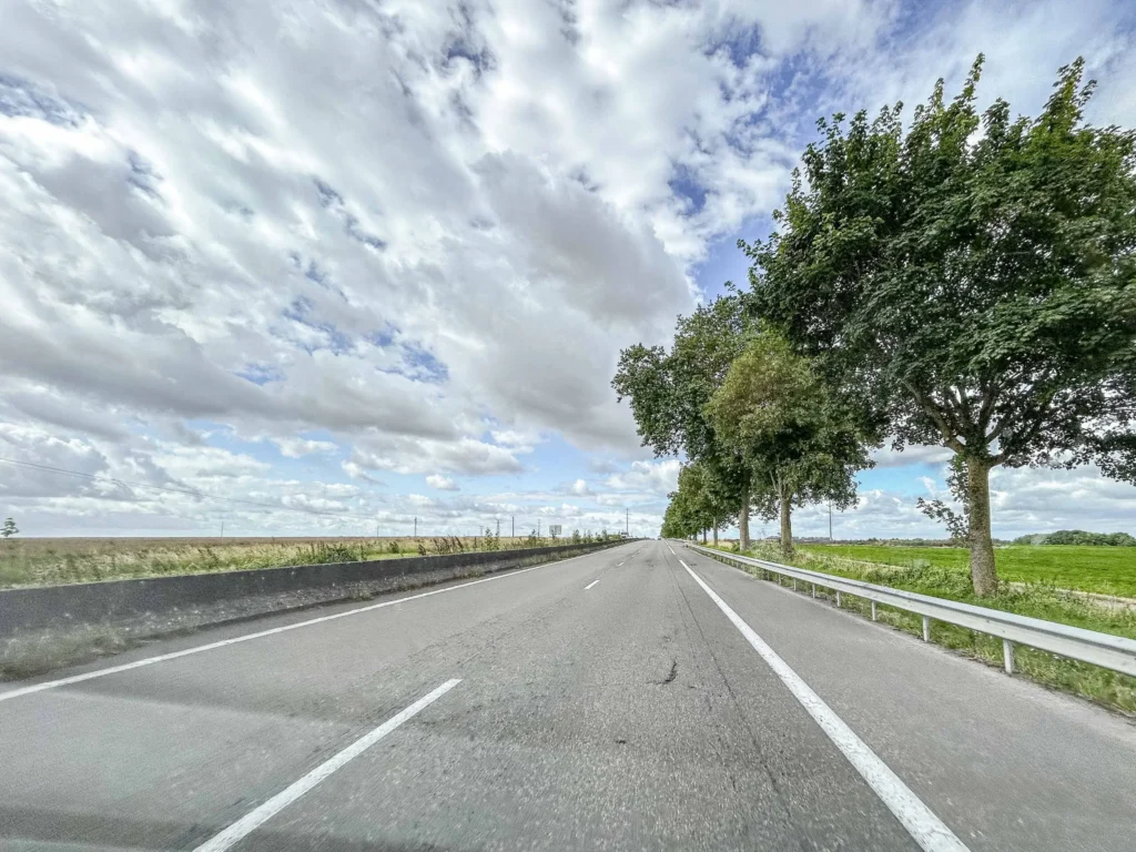 Straße mit Baum unter einem sommerlichen Himmel